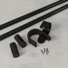 A collection of black curtain rod hardware components laid out on a textured gray surface. Podgląd zdjęcia produktu