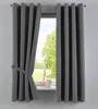 A dark gray curtain is tied back with a fabric strap, revealing a window with a view of trees and a green field. A pink vase and a white pot sit on the windowsill. Produktbild-Vorschau