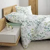 A close-up view of a bed with bedding and a nightstand. Produktbild-Vorschau