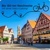 A street scene in a European town with historic buildings and people walking and cycling. Anteprima dell’immagine prodotto