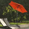 An orange patio umbrella is set up next to two wooden lounge chairs in a garden setting. Produktbild-Vorschau