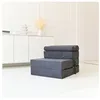 A folded mattress is displayed in a minimalist room with white walls and a white cabinet in the background. Podgląd zdjęcia produktu