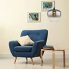 A blue armchair with a pillow sits next to a small wooden table with books, under a pendant light. Anteprima dell’immagine prodotto