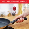 A hand holding a frying pan handle in a kitchen setting. Produktbild-Vorschau