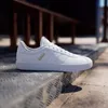 A white Adidas sneaker is placed on a metal step outdoors. Produktbild-Vorschau