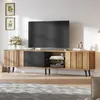 A modern wooden TV stand with a large TV on top, situated in a well-lit room with artwork on the wall. Produktbild-Vorschau