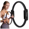 A woman is holding a pilates ring in front of a larger pilates ring. Podgląd zdjęcia produktu
