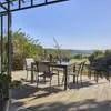 An outdoor dining set on a wooden deck with a scenic view of rolling hills. Anteprima dell’immagine prodotto