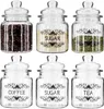 A set of six glass jars with lids, arranged in two rows of three, containing coffee beans, sugar, and tea leaves. Each jar has a decorative label indicating its contents. Produktbild-Vorschau