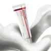A tube of cream is shown emerging from a swirl of white liquid. Voir les images du produit