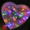 A heart-shaped box filled with colorful LED string lights. Produktbild-Vorschau