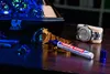 A close-up of a watch being marked with a UV marker under blue light. Produktbild-Vorschau