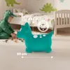 A child in a dinosaur costume plays with toy dinosaurs near a green inflatable dinosaur in a bedroom. Podgląd zdjęcia produktu