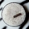 A close-up overhead view of vanilla sugar in a dark bowl, with a piece of vanilla bean resting on top. Produktbild-Vorschau