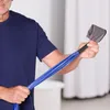 A man is holding a blue resistance band with a gray handle. Voir les images du produit