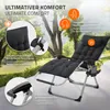 A black reclining lounge chair with a cushion, set up outdoors on a patio with trees and greenery in the background. Produktbild-Vorschau