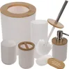A collection of bathroom accessories, including a trash can, soap dispenser, toilet brush, toothbrush holder, soap dish, and cup, all with white bodies and bamboo accents. Voir les images du produit