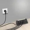 A black corner power strip with three outlets and USB ports is plugged into a white wall socket. The power strip is on a light wood surface. Produktbild-Vorschau