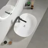 A modern bathroom countertop with two white ceramic sinks and black faucets. Anteprima dell’immagine prodotto