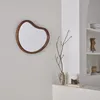 A mirror and decorative items are displayed on a shelf and wall in a room. Anteprima dell’immagine prodotto
