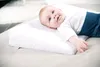 A baby lying on a white wedge pillow. Anteprima dell’immagine prodotto