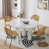 A dining table with chairs in a well-lit room, set on a rug with a modern design. Produktbild-Vorschau