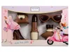 A box of chocolates shaped like fashion items, with illustrations of women and a scooter. Produktbild-Vorschau