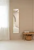 A minimalist bedroom with a full-length mirror and a bench. Náhled obrázku produktu