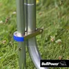 Close-up view of metal poles with a blue clamp, set against a grassy background with some small white flowers. Produktbild-Vorschau