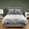 A bed with gray bedding is shown in a room with a dark green wall. Náhled obrázku produktu