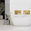 A modern bathroom with a freestanding bathtub, a gold faucet, and decorative shelves. Produktbild-Vorschau