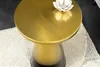 A close-up shot of a gold side table with a decorative item on top, placed on a rug. Produktbild-Vorschau
