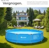 A large round blue swimming pool is set up on a green lawn in front of a modern white house. There are lounge chairs and a patio umbrella in the background. Náhled obrázku produktu