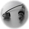 A black electrical connector with a protective cap attached by a thin strap, resting on a textured gray surface. Produktbild-Vorschau