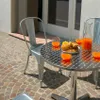 An outdoor table setting with chairs, drinks, and pastries. Voir les images du produit