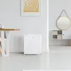 A modern minimalist room with a white mini-fridge, a dining table, and a decorative wall mirror. Voir les images du produit