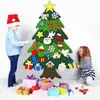 Two children decorating a felt Christmas tree with ornaments and gifts at the base. Produktbild-Vorschau