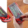 Rotes auto-förmiges Wasserspielzeug mit Lenkrad, in Händen auf Holzoberfläche gehalten Anteprima dell’immagine prodotto