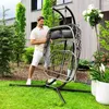 A man is assembling a hanging chair in a garden. Produktbild-Vorschau