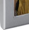 A close-up view of a silver picture frame with a portion of a photo visible inside, showing a person wearing a fringed garment. Náhled obrázku produktu