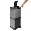 A person's hand is shown pressing a button on a gray and black trash can. Produktbild-Vorschau