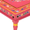 A close-up view of a pink wooden table with hand-painted floral designs. Produktbild-Vorschau