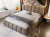 A bedroom scene with a bed as the focal point, decorated with pillows and a throw blanket. Two small side tables with decorative items are placed on either side of the bed. A large artwork is mounted on the wall behind the headboard. Produktbild-Vorschau