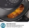 A close-up shot of a black air fryer with food cooking inside, showing the brand name and a feature description. Náhľad obrázku produktu