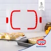 A baking tray with a transparent lid and red handles, with slices of cake on a cooling rack and in the tray. Anteprima dell’immagine prodotto
