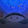 A plush toy projector with a smiling face, projecting a blue ocean scene with fish onto a dark surface. Náhled obrázku produktu