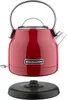 A red KitchenAid electric kettle is shown with its black base, presented in a studio-like setting with a white background. Produktbild-Vorschau