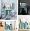 A collage of images showing a light blue vanity table with LED lights and mirrors, along with a stool and storage drawers, in different room settings. Voir les images du produit