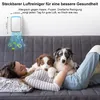 A woman and two puppies are relaxing on a couch, with an air purifier mounted on the wall above them. Produktbild-Vorschau