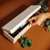A hand is shown closing a wooden wine box, with chocolates scattered in front. Produktbild-Vorschau